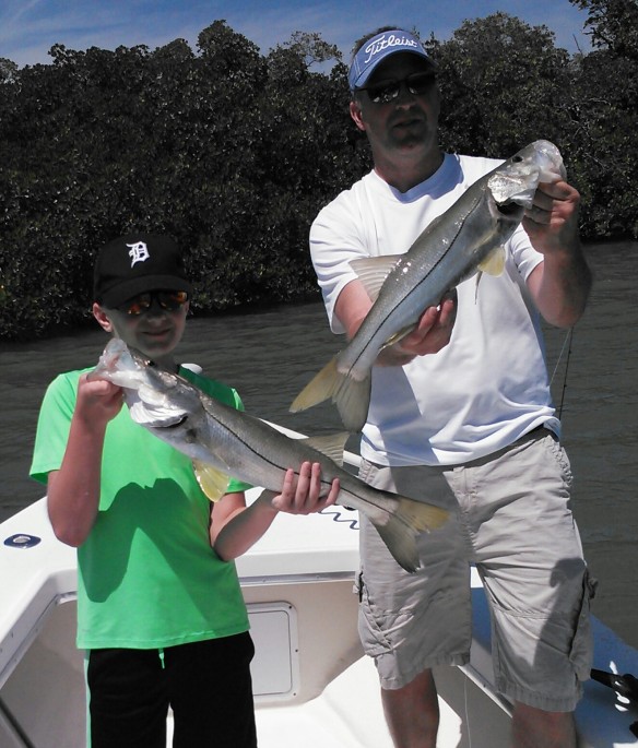 Young angler Nick Seitz and dad, Mike with a nice double on snook during a recent April trip. 